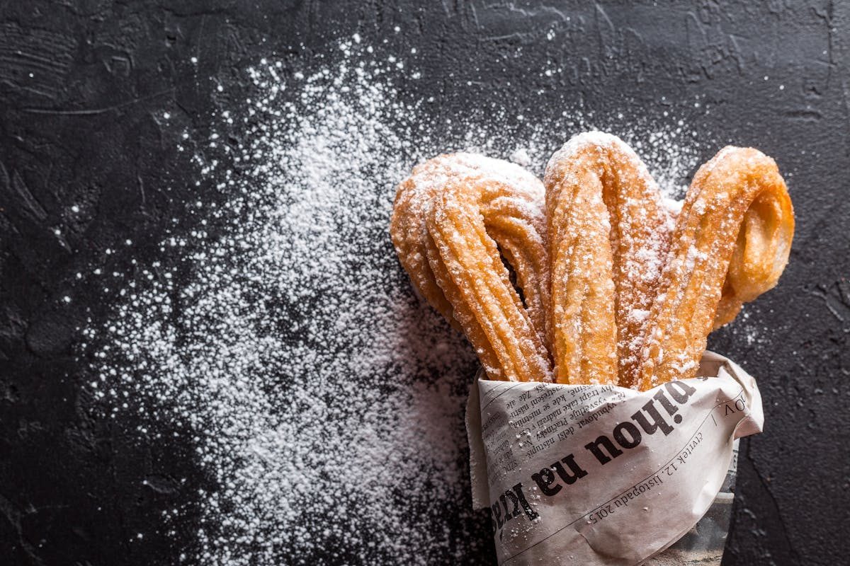 churro with sugar on black background