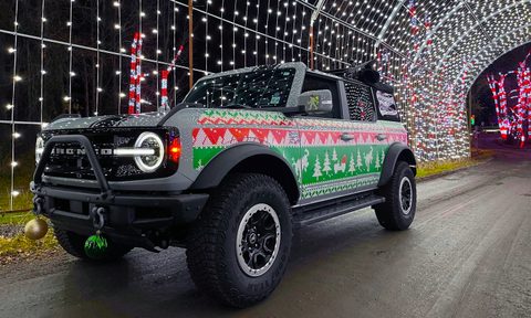 A Ford Bronco parked inside a holiday light tunnel and wrapped in Mek Magnet's "Ugly Sweater" holiday-edition vehicle wrap.