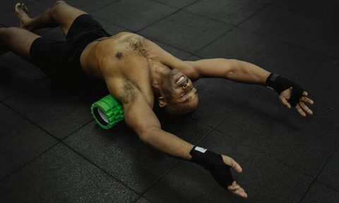 man foam rolling on back smiling