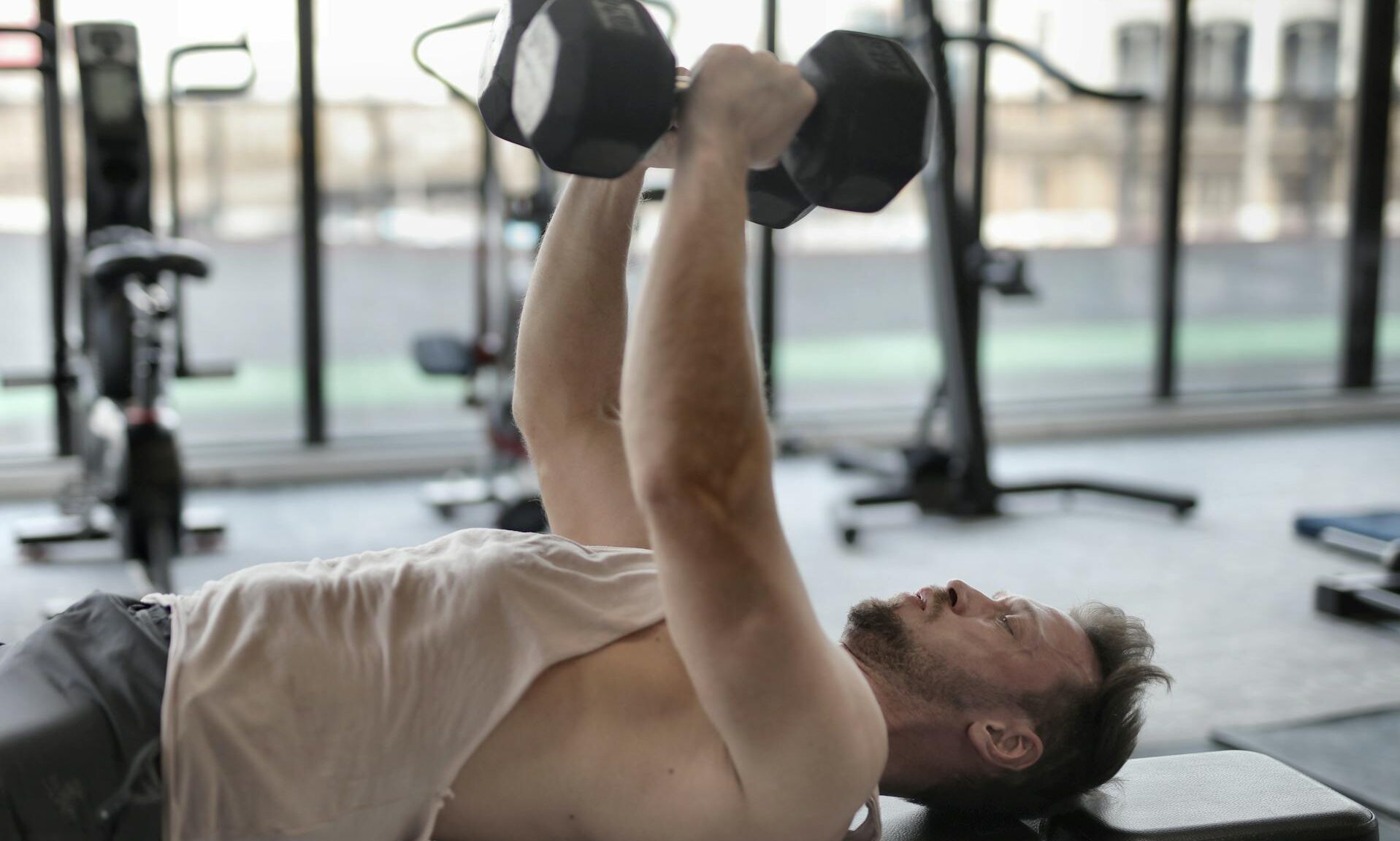 man lifting weights dumbbells in gym