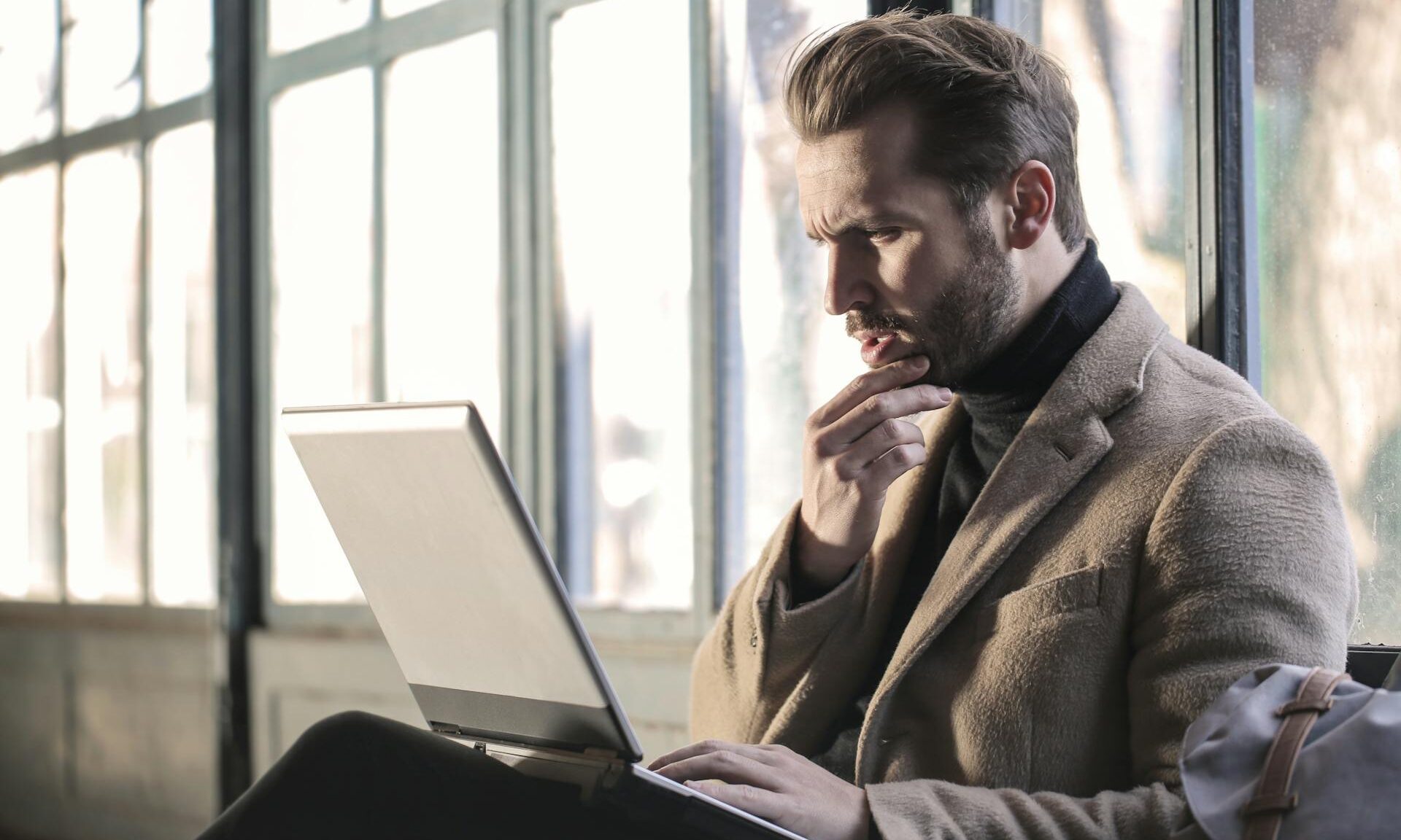 man working on laptop thinking