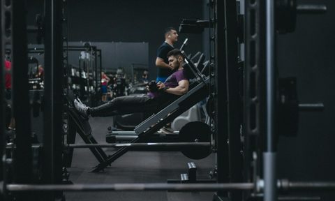 man leg machine gym working out