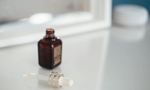 oil in a brwon bottle on white vanity