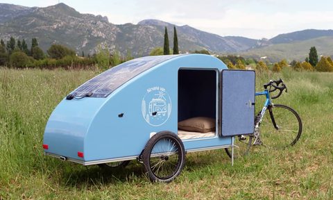 A Nirvana Van Bike Camper parked in a grass field.