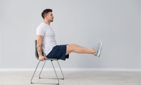 man doing chair exercises leg