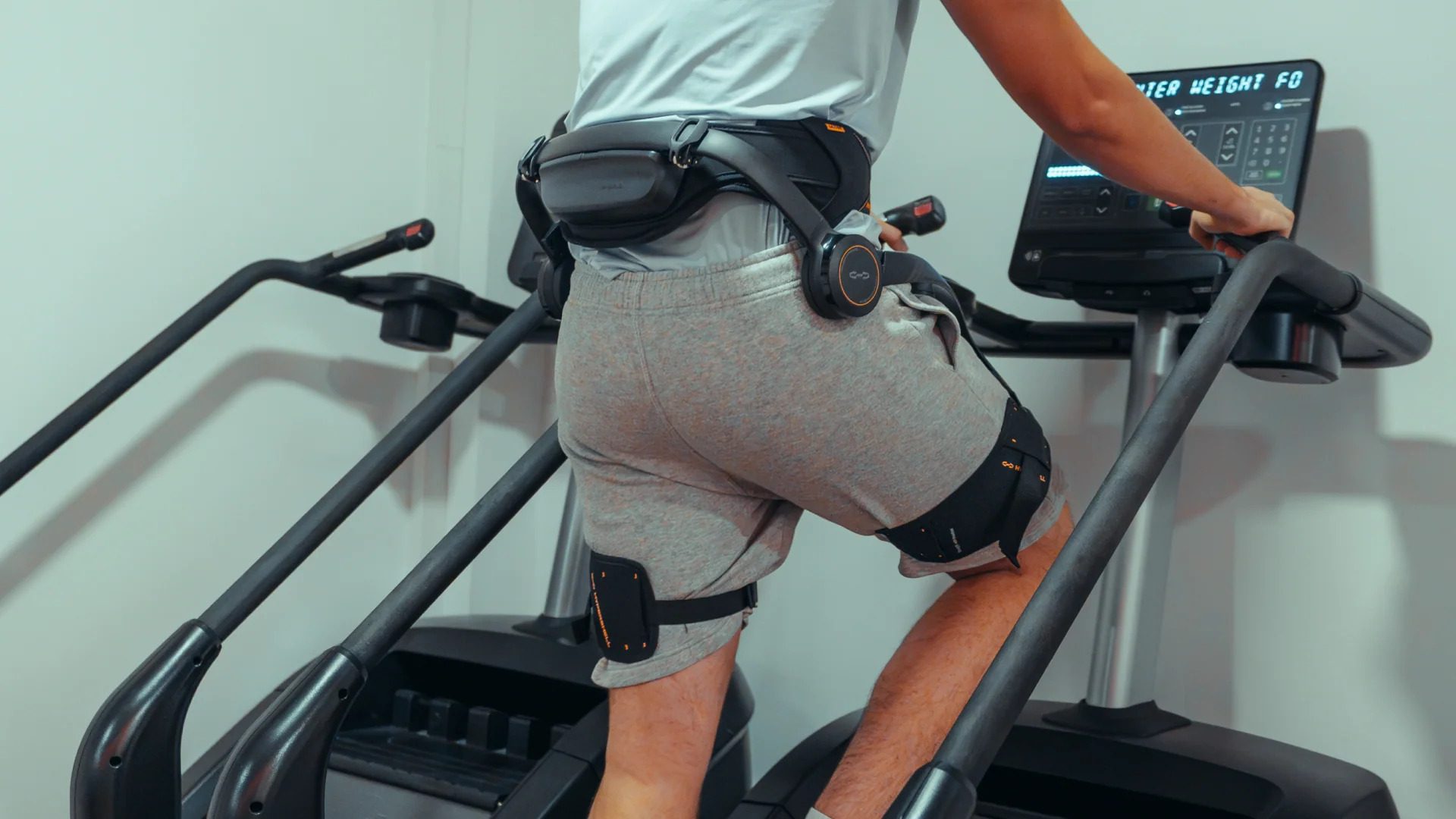 A man using a stair stepper wearing a Hypershell Exoskeleton
