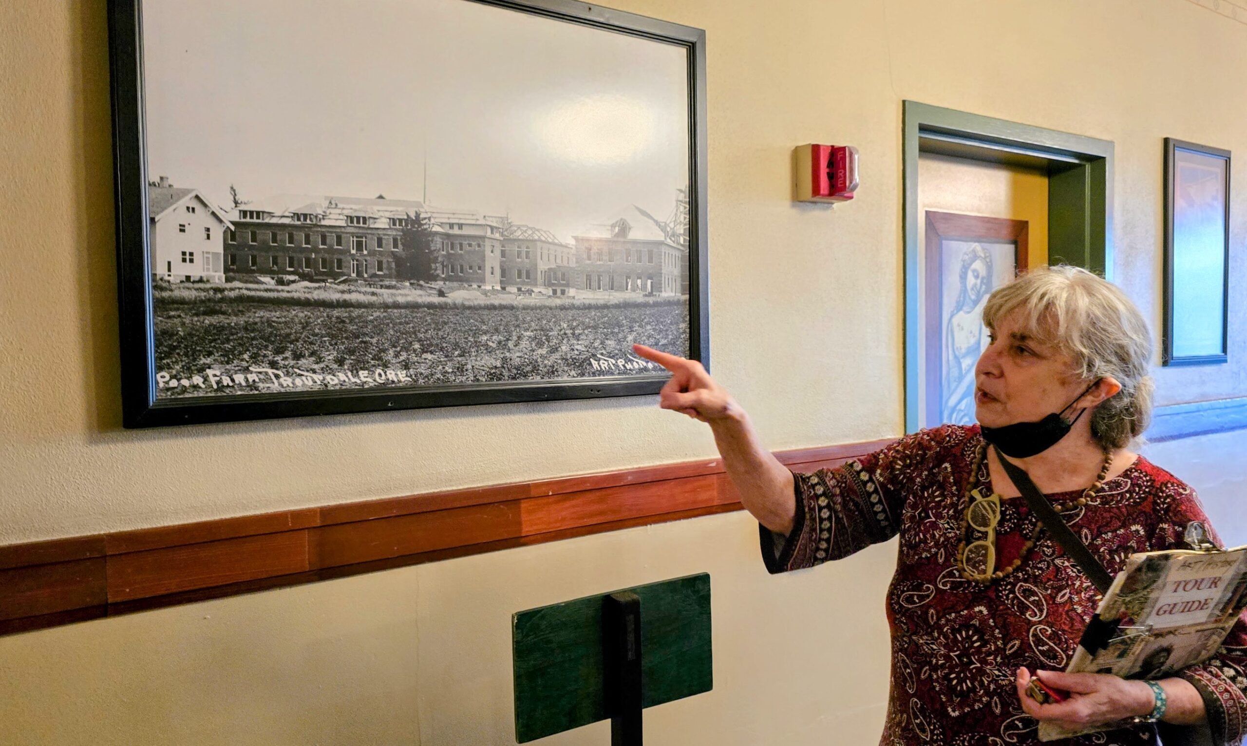 A tour guide explaining the history of Edgefield while pointing at a historic photo