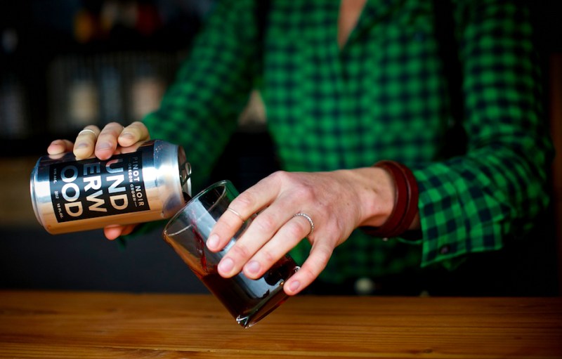 pouring pinot noir into glass from can