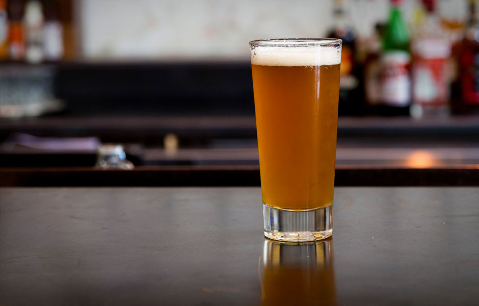 A beer served in a pint glass on a table.