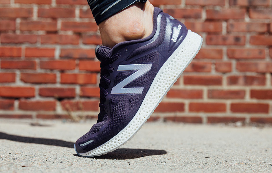 A New Balance shoe walking on the sidewalk.