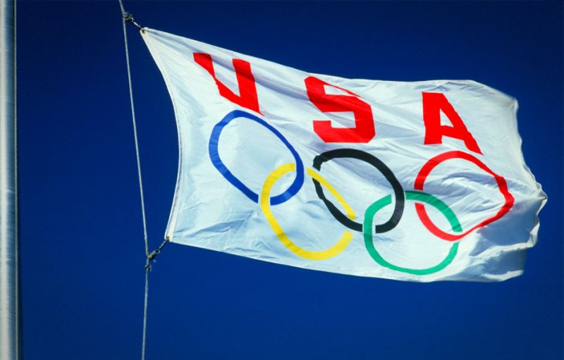 The USA Olympic flag flying against a blue sky. 