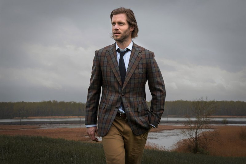 A man in a plaid blazer and beige chinos