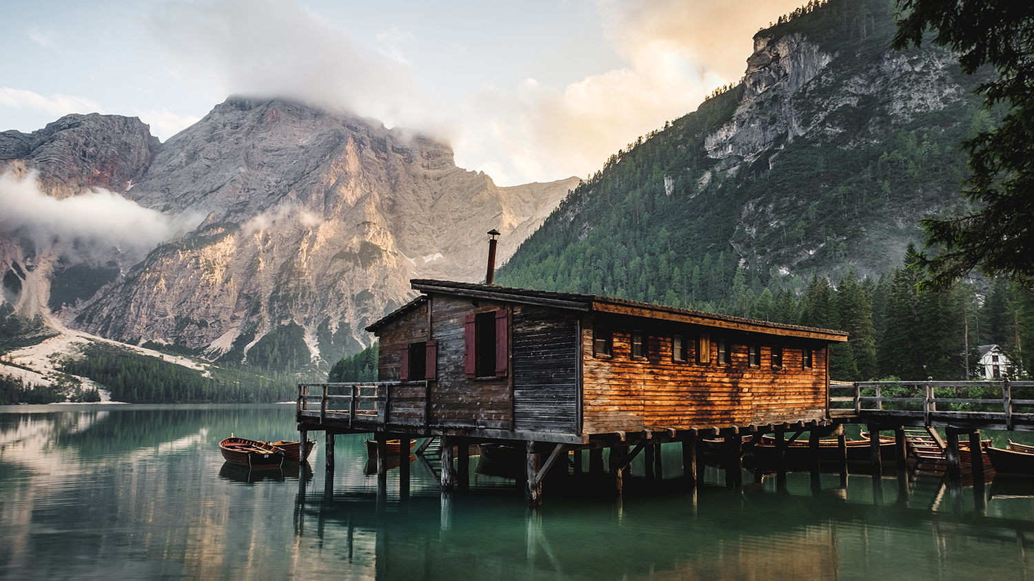 Cabin in the woods with mountains in the background.