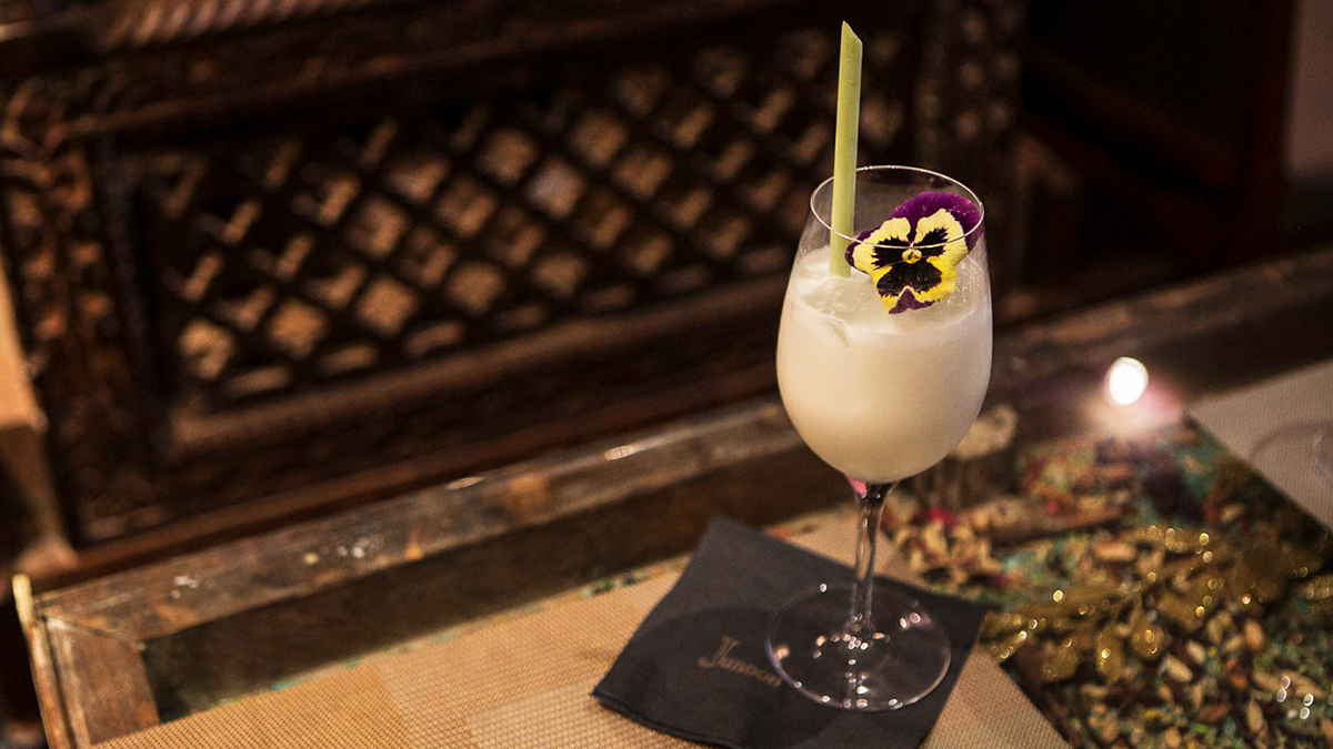 Junoon Coconut Cocktail in a wine glass.