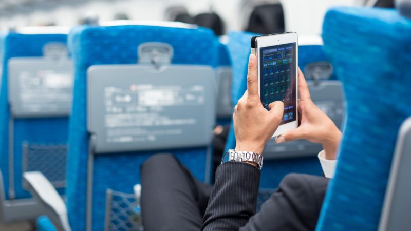 Man using his phone on an airplane.