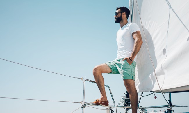 man on boat wearing shorts and sunglasses