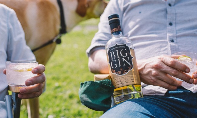 big gin peat barreled gin in lap of man in lawn chair outside