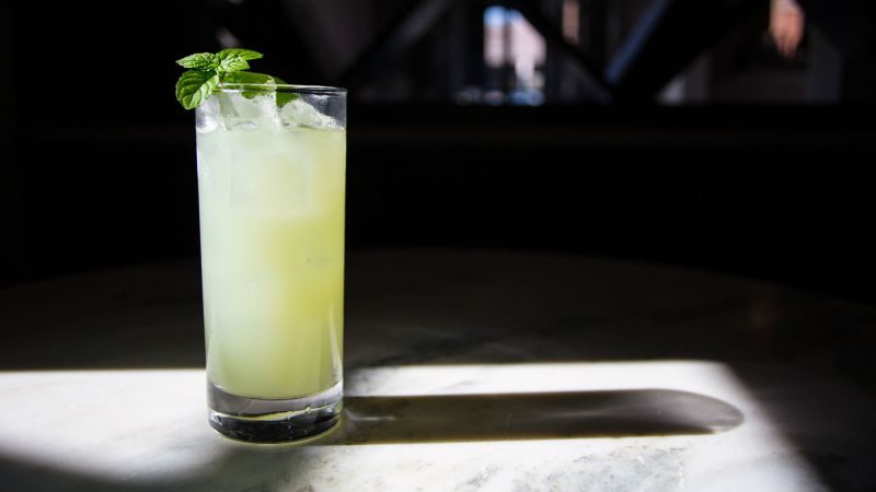 A Maid in Scotland cocktail garnished with mint leaf on a table.