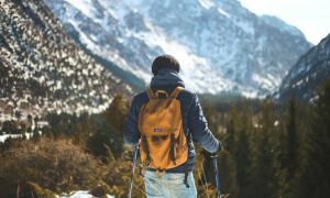 Man hiking with poles near a mountain