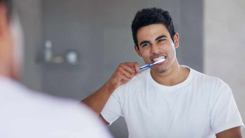 man brushing teeth bathroom