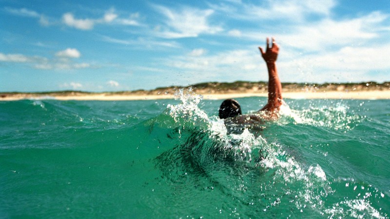 man swimming out of rip current