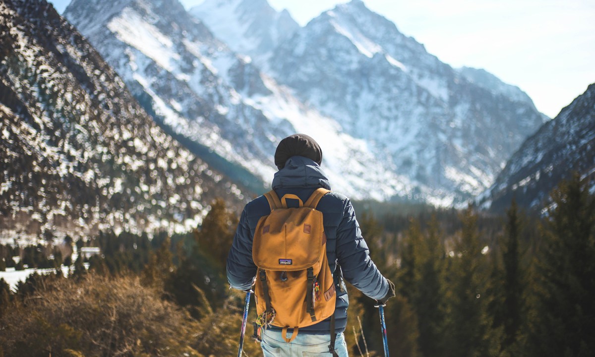 Man outside using hiking trekking poles and Patagonia backpack