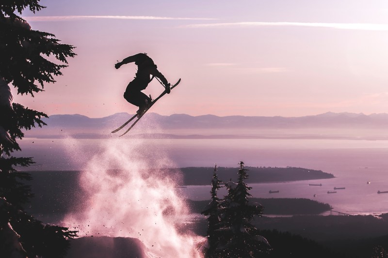 Silhouette of a skier jumping high in the air.