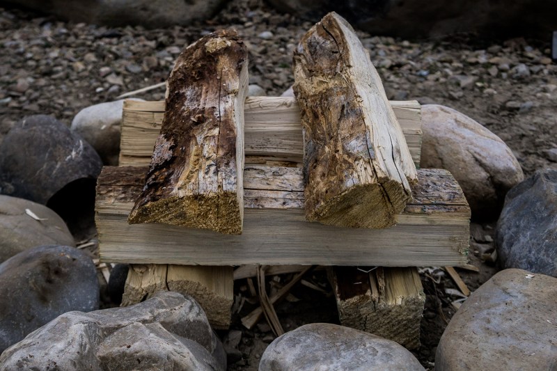Stacks of wood surrounded by rocks.