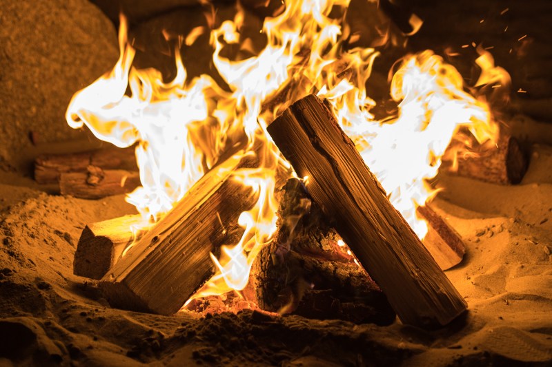 Sticks of wood burning at a campfire.