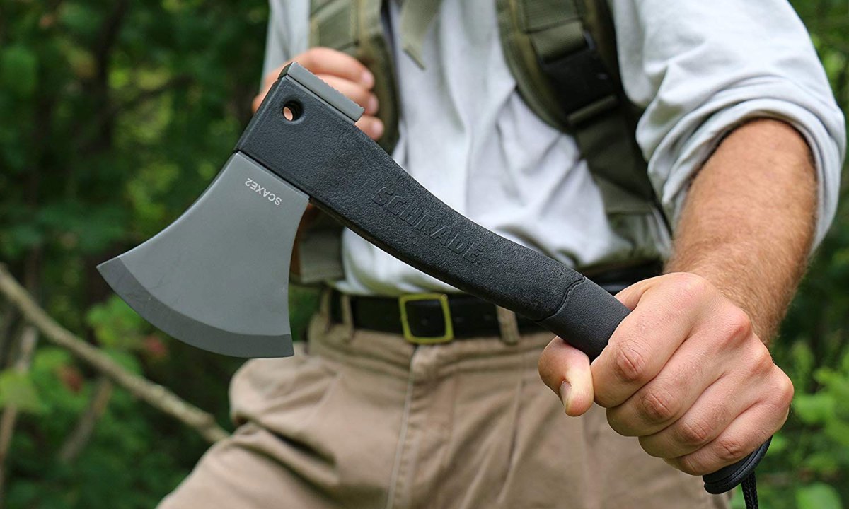 A midsection of a man wielding a hatchet in the outdoors