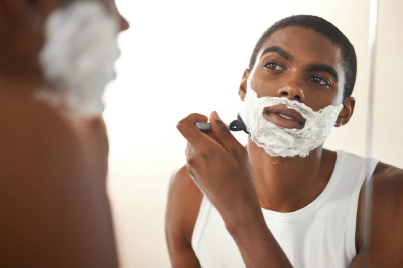 Man shaving with shaving cream and razor