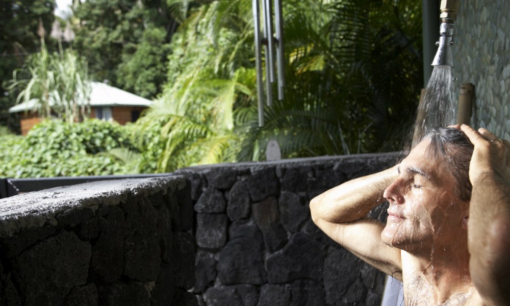 Man taking a shower outdoors in the jungle