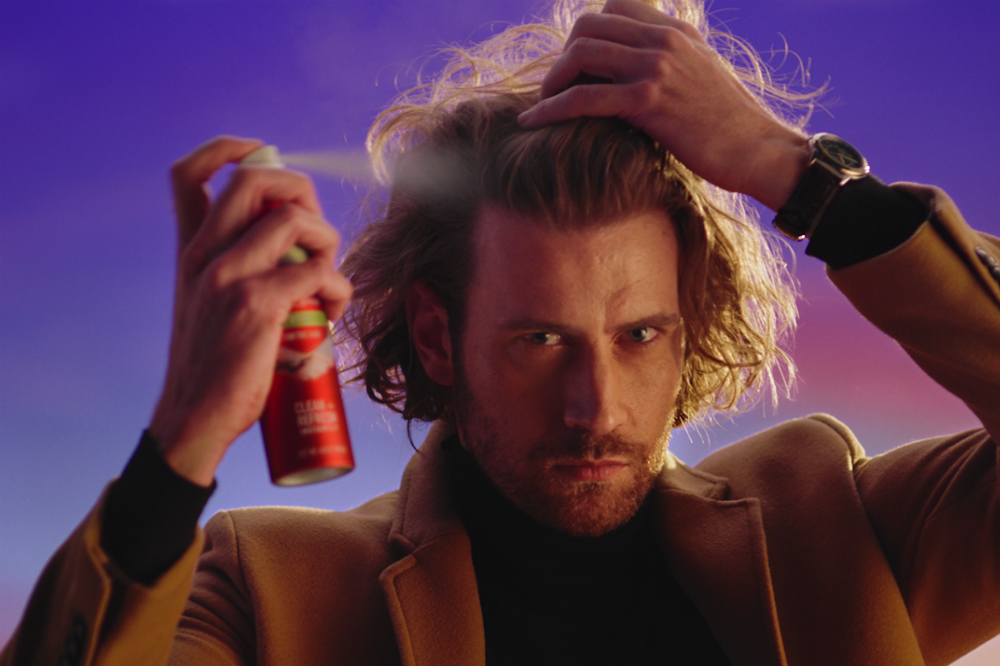 Many spraying dry shampoo in his hair