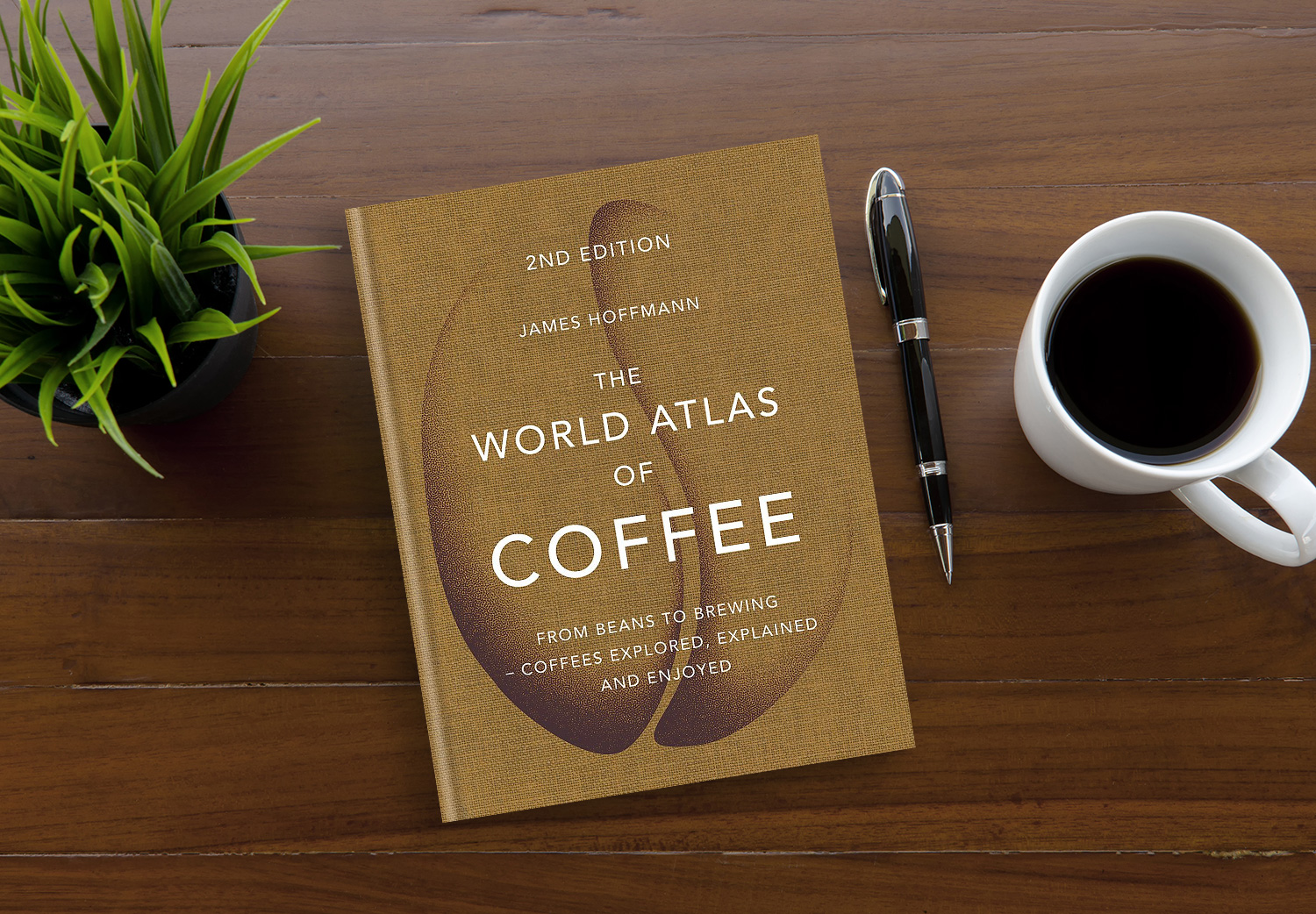 The World Atlas of Coffee by James Hoffman on a wooden table.
