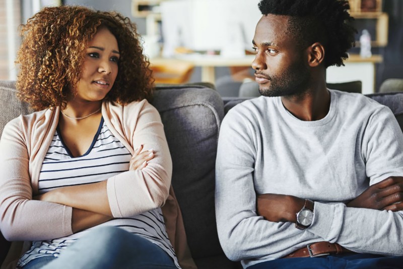 couple talking to each other on a couch.