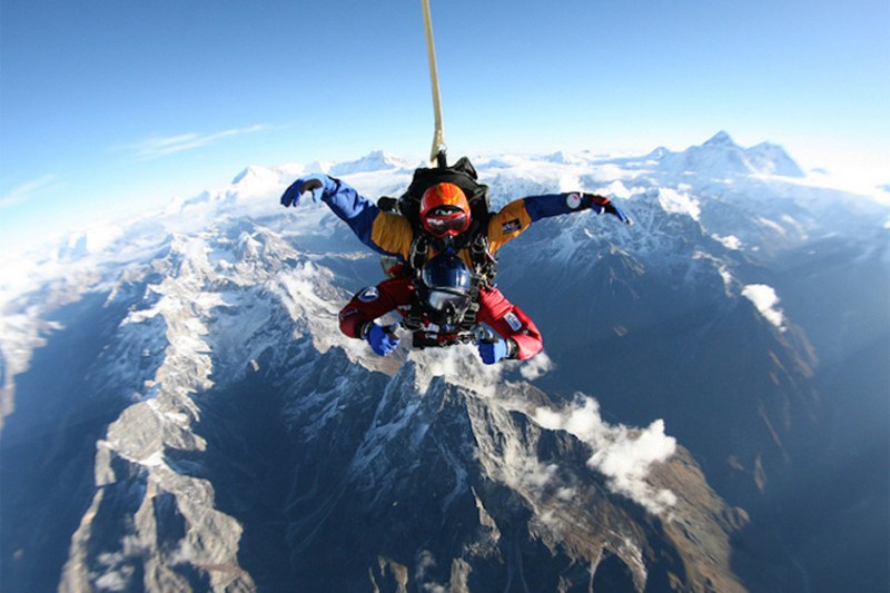 Skydivers jumping from a helicopter over Mount Everest.