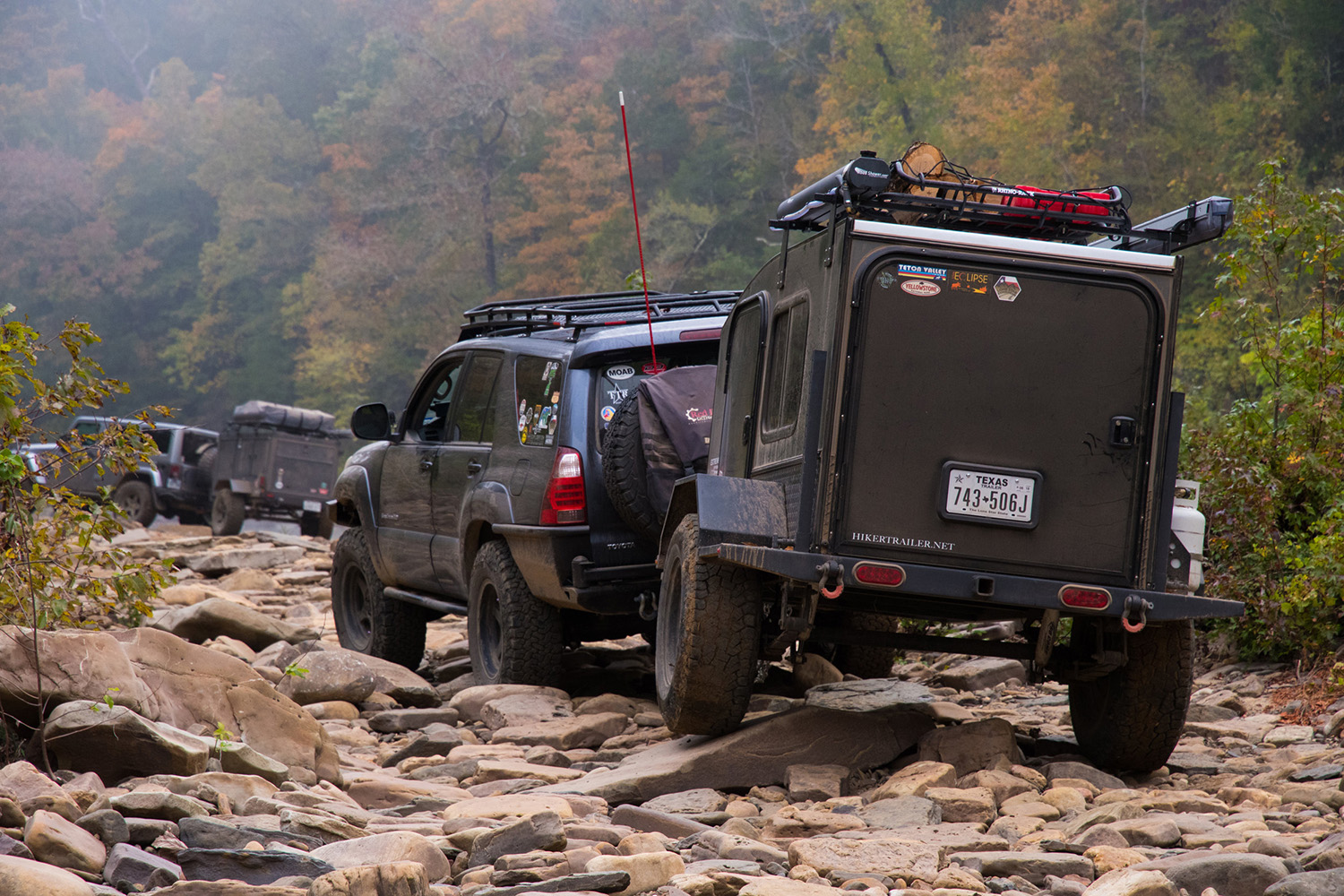 Hiker Trailer travel trailer driving on a rugged, off-road trail.
