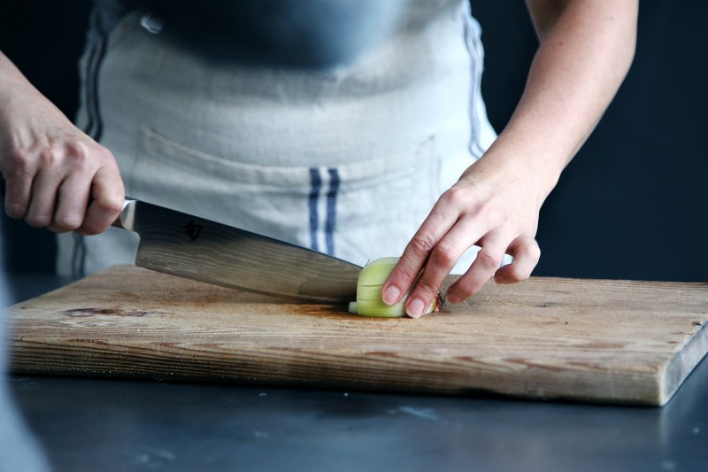 knife cutting onions board