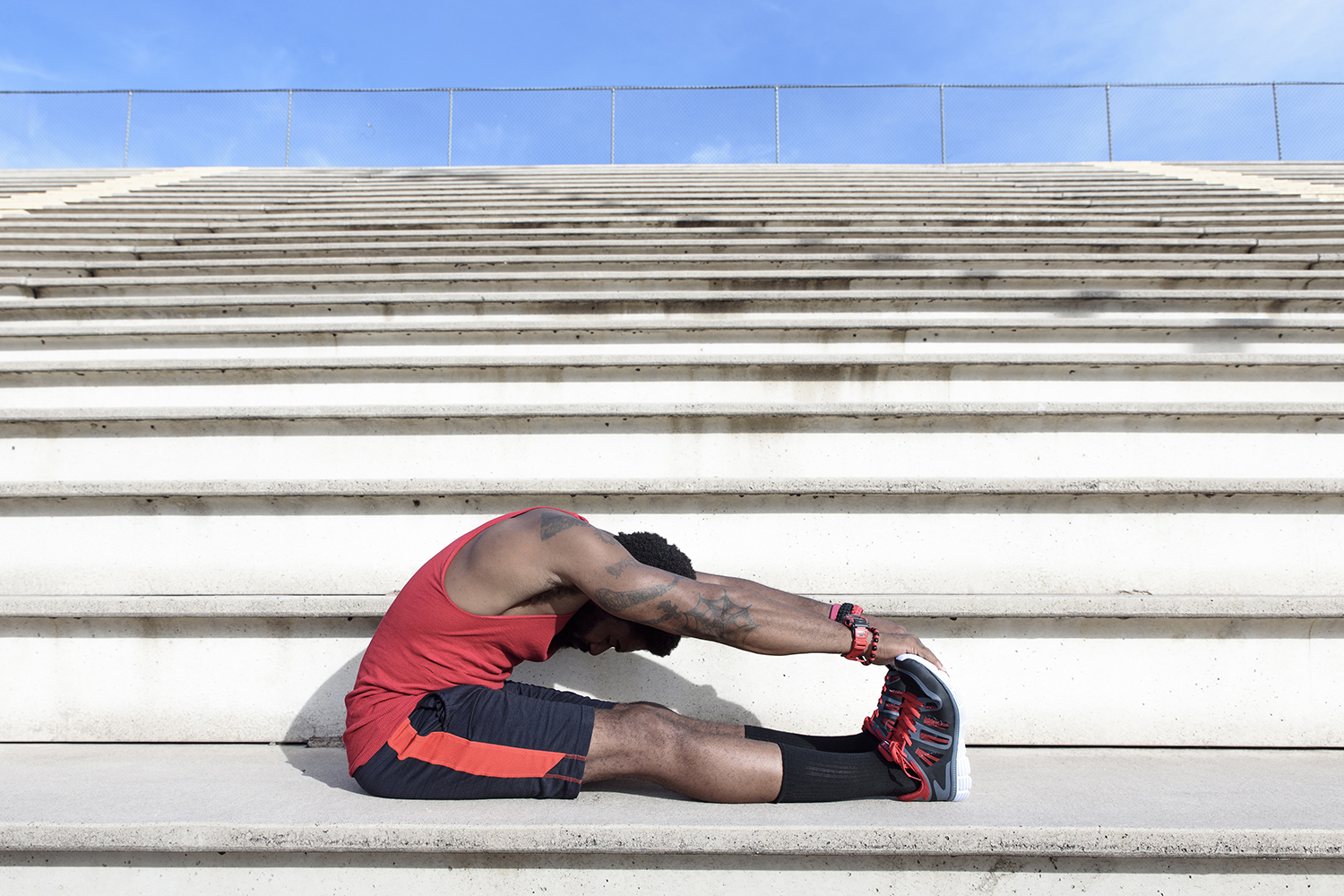 Man stretching his legs and arms before working out.