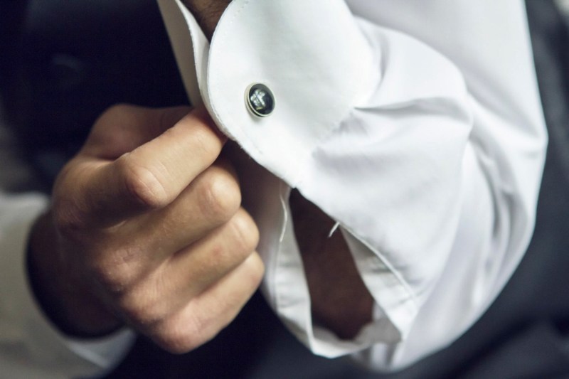 Man putting on a cufflink