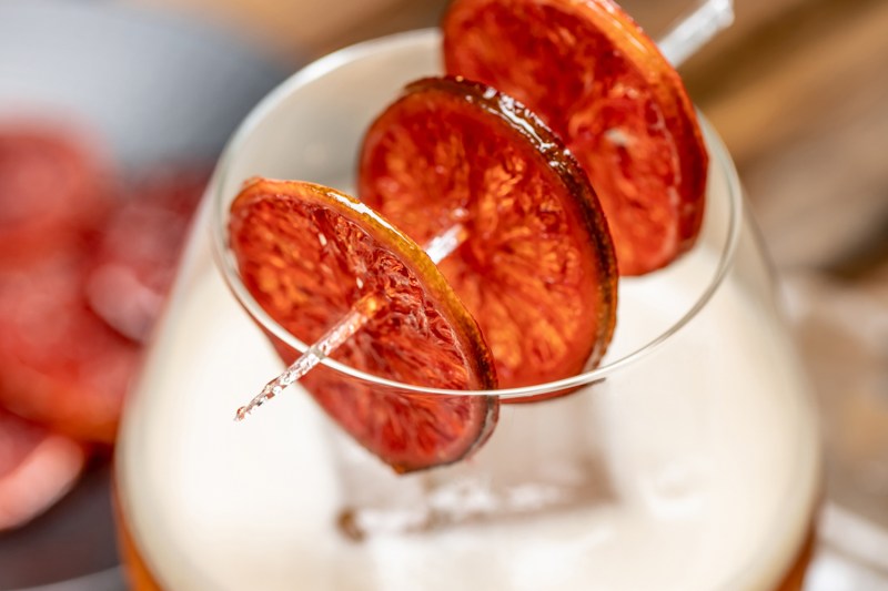 A close-up of skewered, candied limewheels on a glass of Sole Rosso