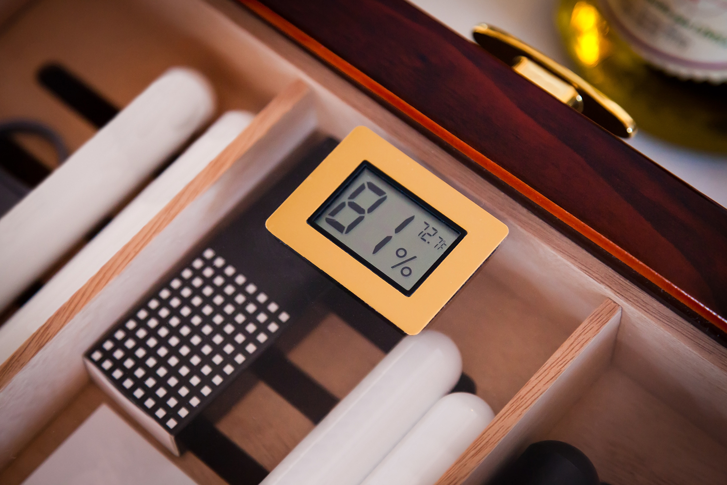 Cigar humidor gauge that shows percentage and temperature.