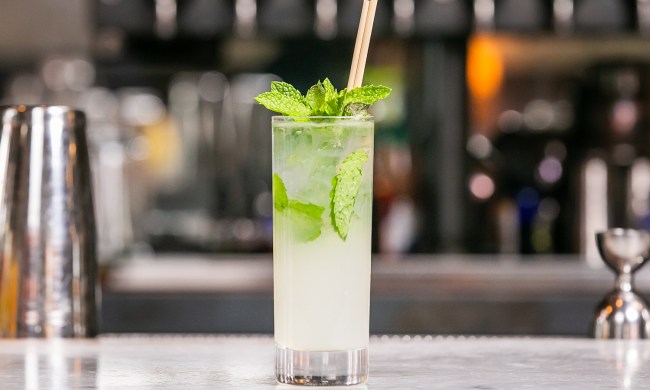 A mojito cocktail sitting on the bar
