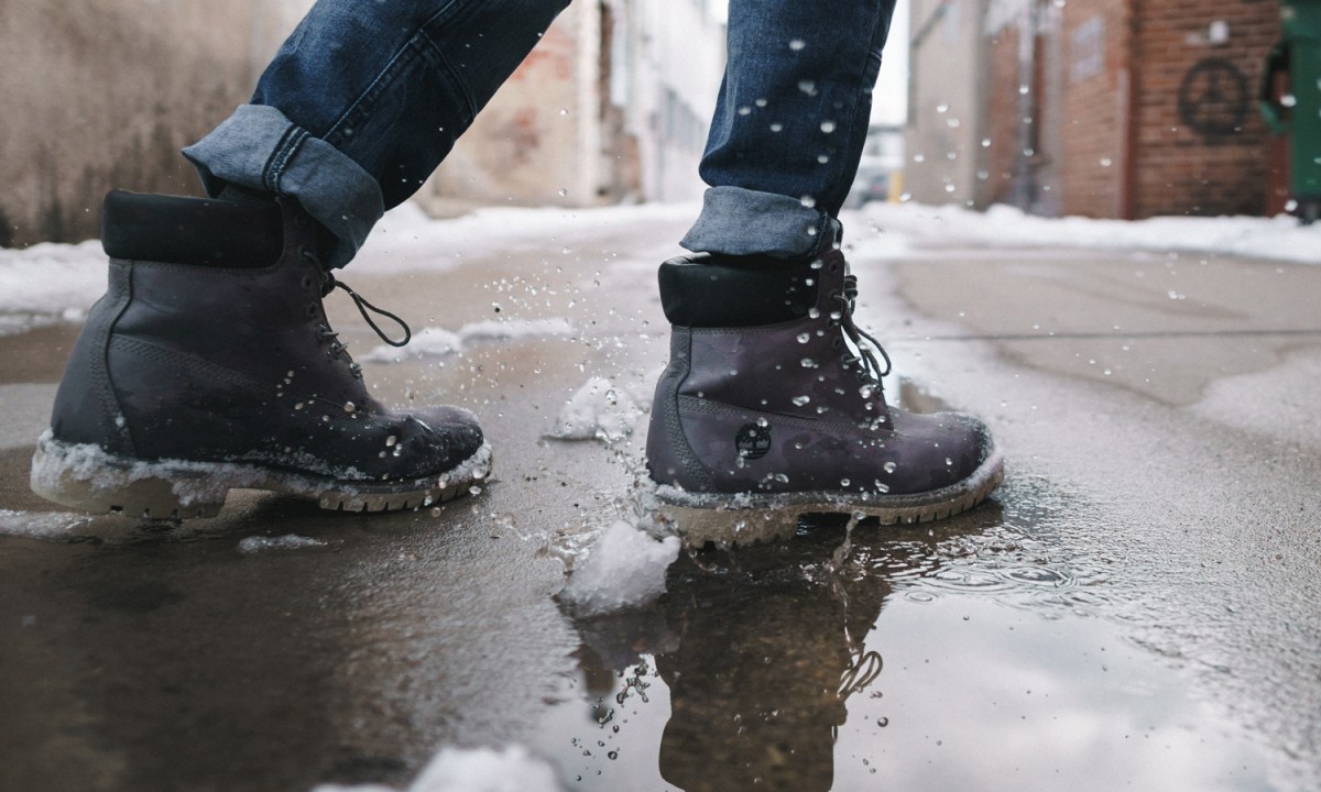 Person wearing pair of gray leather boots