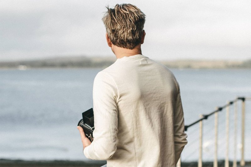 man in a henley shirt staring over the ocean.