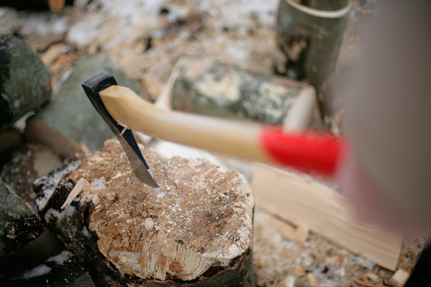 Closeup of a wooden axe splitting a piece of wood.