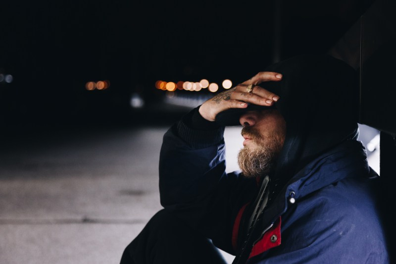 Man sitting on the ground looking sad