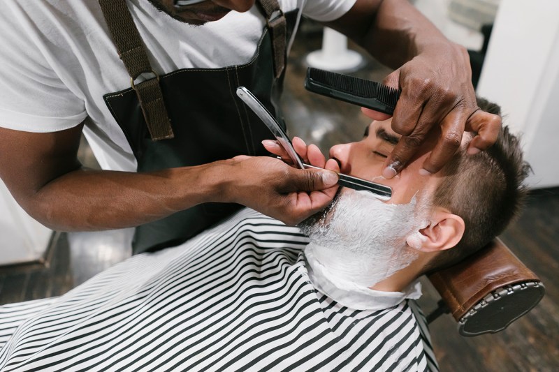 Man getting a straight razor shave from a barber.