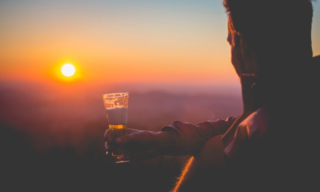Man drinking at sunset.