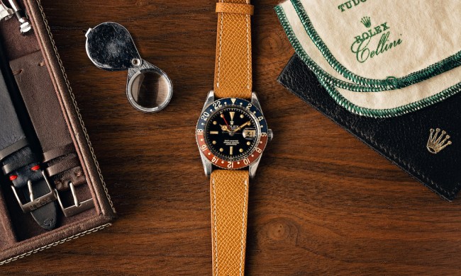 Rolex watch with other accessories by it.
